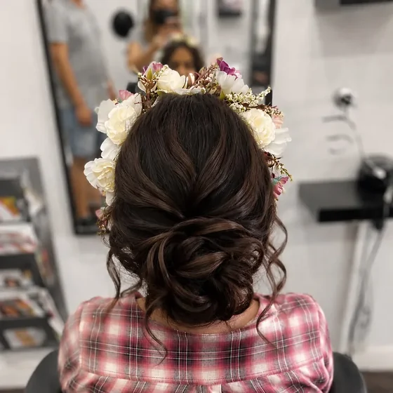 Textured low bun dressed with a floral crown, by Sadaf Bridal
