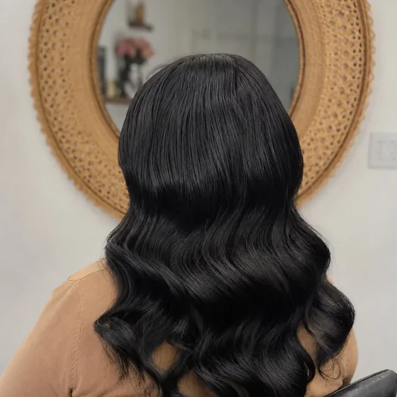 Long dark hair styled in glossy waves, by Sadaf Bridal